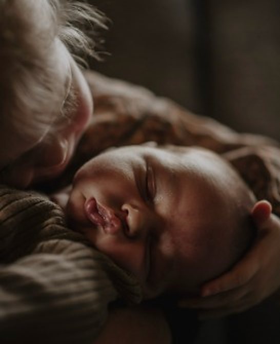 Newborn in de armen van een familielid